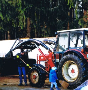 Mann und Kind beim reinigen eines Traktors
